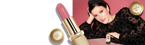 Lisa Eldridge with a pink lipstick and a gold lipstick case on a pink background