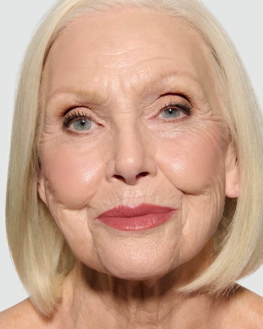 Close-up of a model's face, wearing Fawn Eyeshadow Palette, with a neutral background