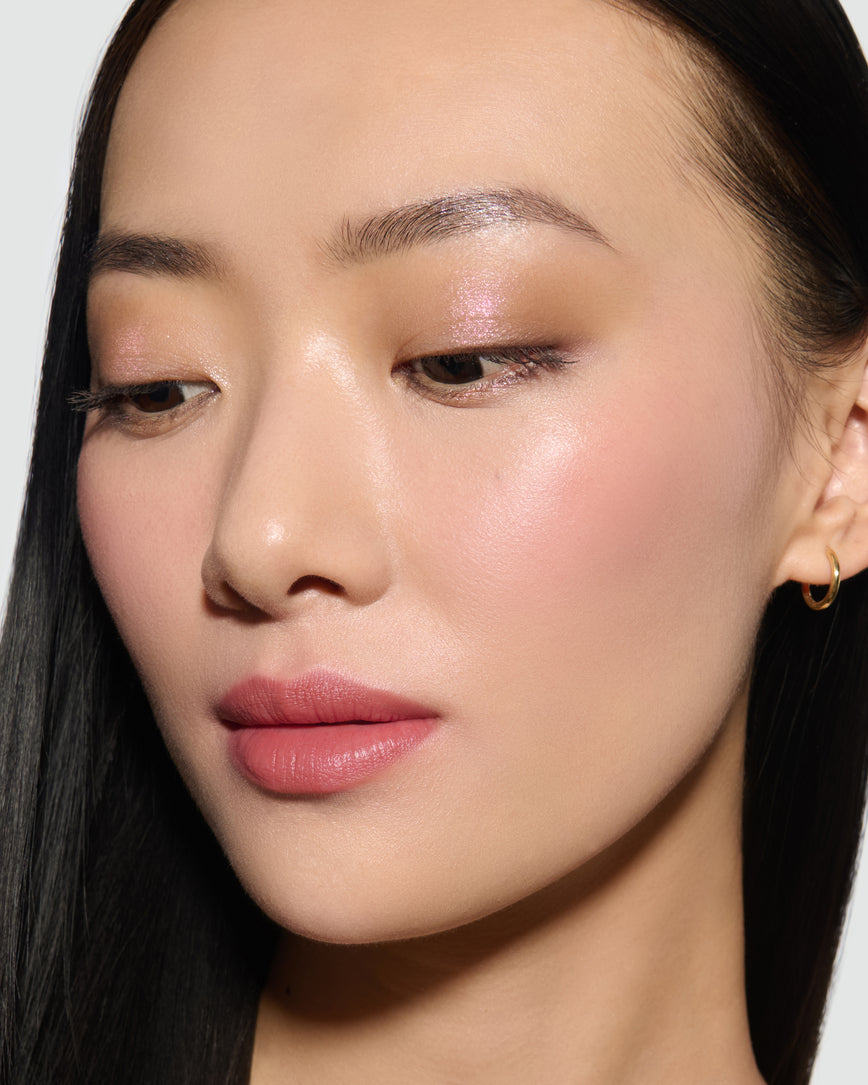Close-up of a model's face, wearing Fawn Eyeshadow Palette, with a neutral background