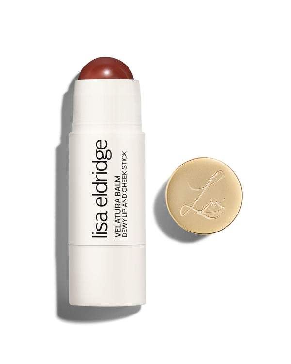 Lisa Eldridge Velatura Balm stick in Cinnamon Bun shade, with cream packaging and golden logo-embossed cap, on a white background