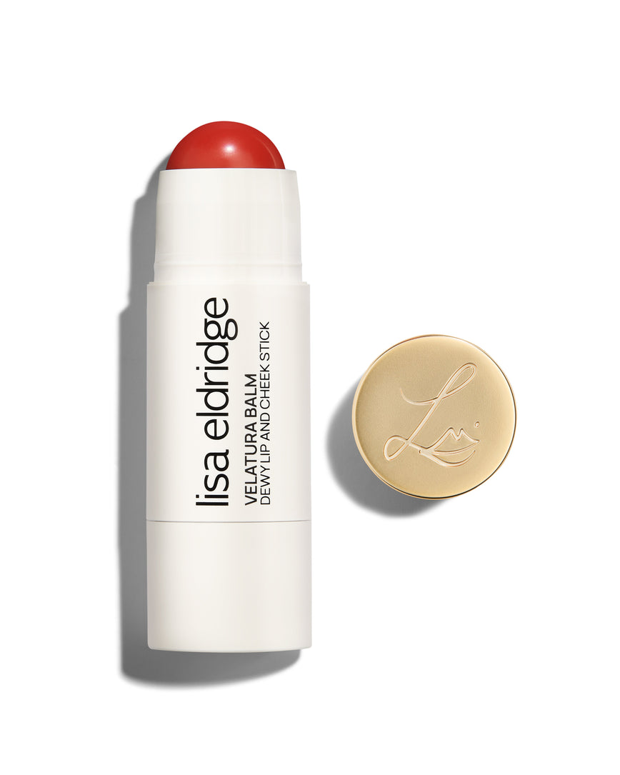 Lisa Eldridge Velatura Balm stick in Pomegranate Glace shade, with cream packaging and golden logo-embossed cap, on a white background
