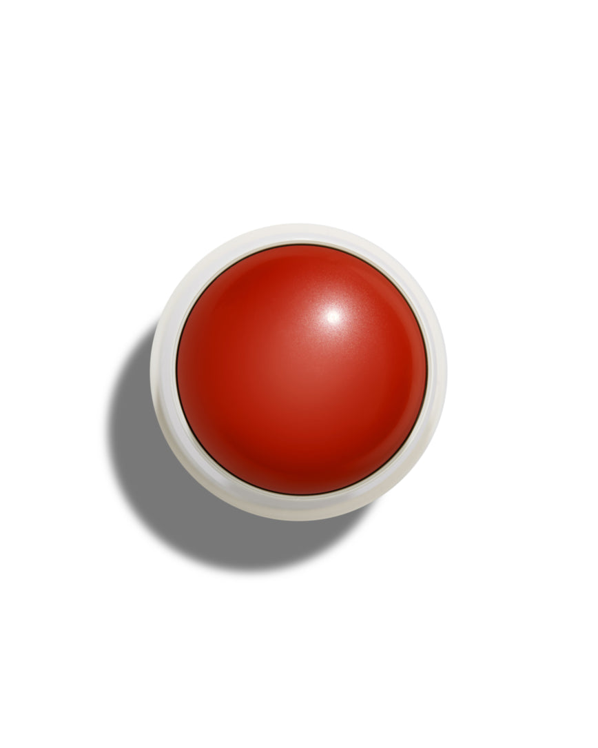 Pomegranate Glace Velatura Balm with white casing on a white background.