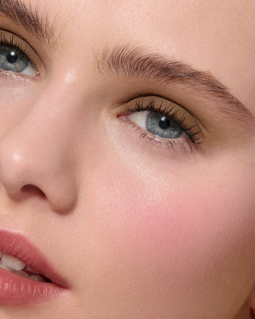 Extreme close up of a model wearing Mimi Liquid Silk Eyeshadow on a neutral background