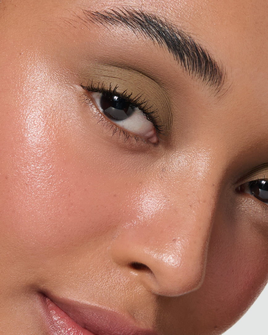 Extreme close up of a model wearing Mimi Liquid Silk Eyeshadow on a neutral background
