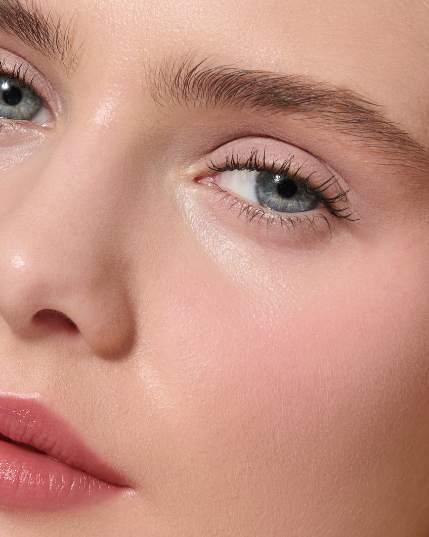 Extreme close up of a model wearing Paige Liquid Silk Eyeshadow on a neutral background