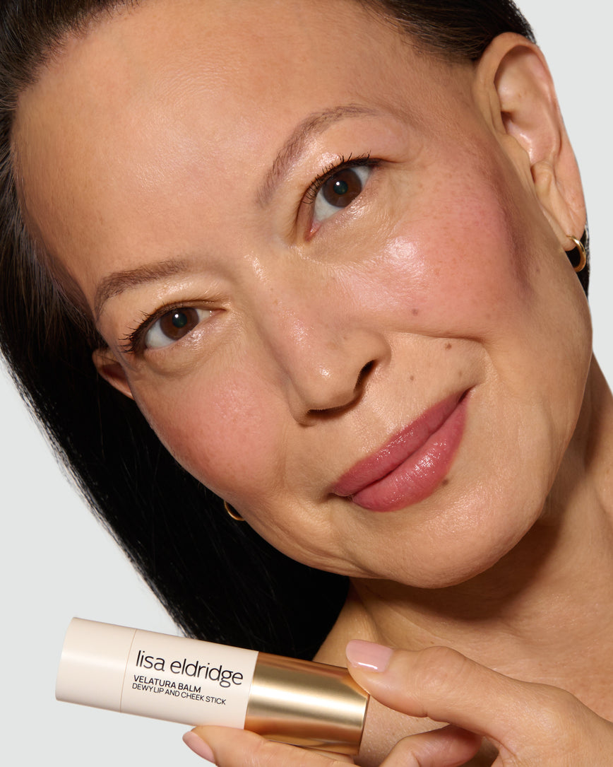 Model holding a Lisa Eldridge Velatura Balm product, with a neutral background